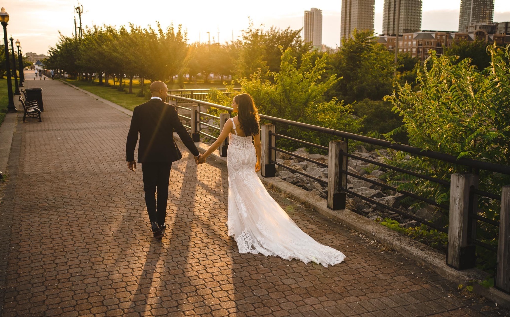 Wedding couple walking at sunset waterfront